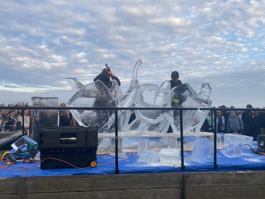 a group of people standing on top of an ice sculpture