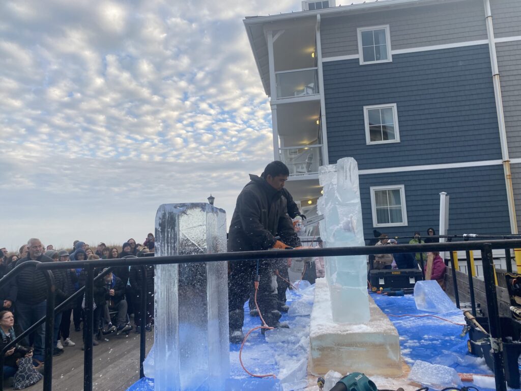 a group of people standing around an ice sculpture