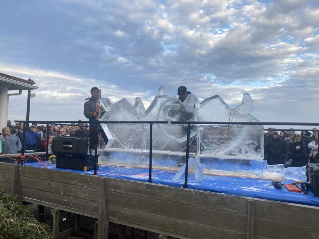 a group of people standing on top of a wooden pier