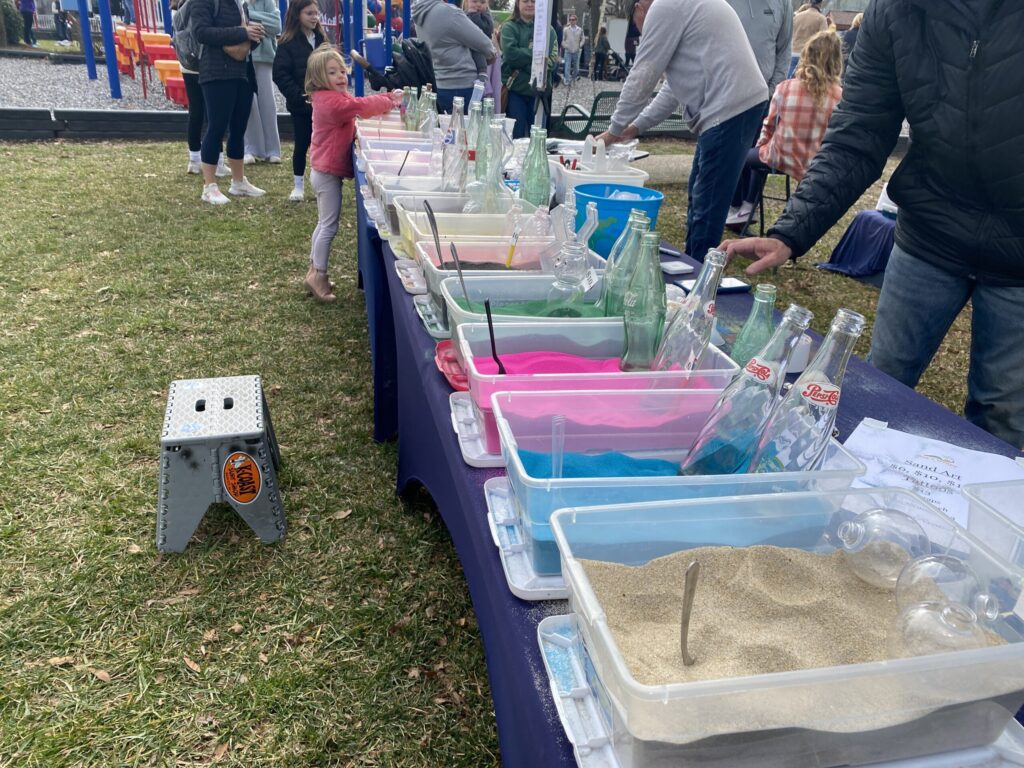 a man standing next to a table filled with bottles