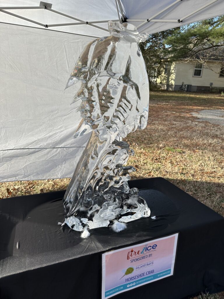 a sculpture of a bird on a table under a tent