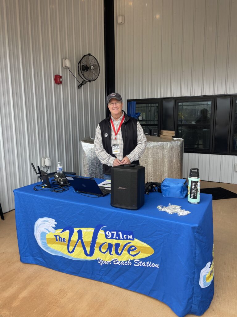 a man standing behind a table with a blue table cloth