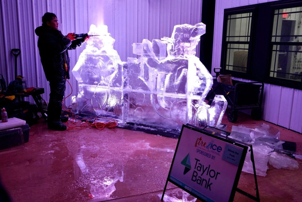 a group of people standing around an ice sculpture