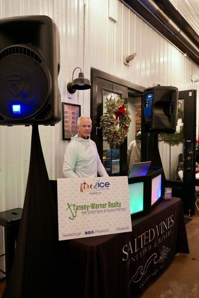 a man standing behind a table with speakers on it