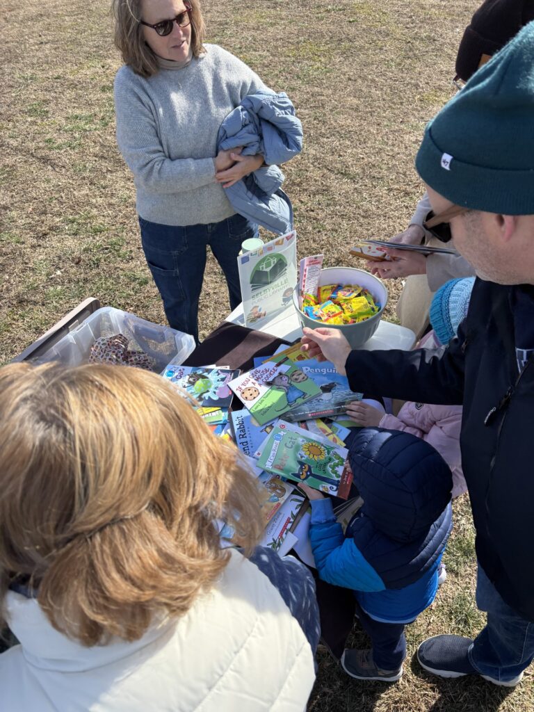 a group of people standing around a table filled with food