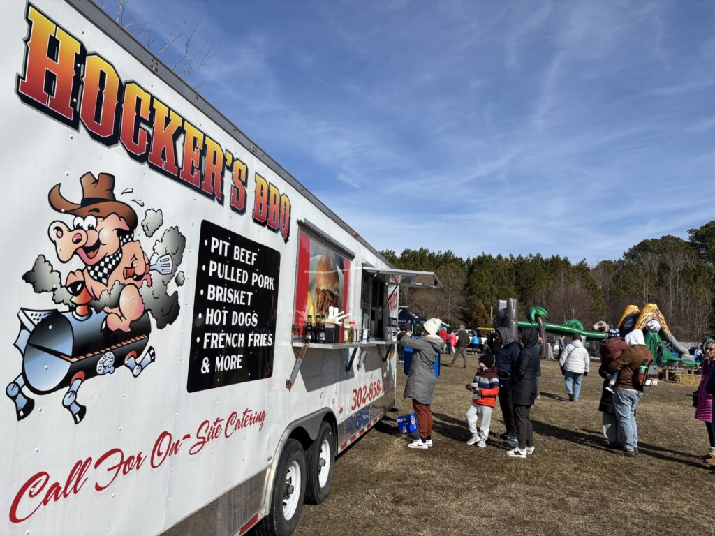 a group of people standing outside of a food truck
