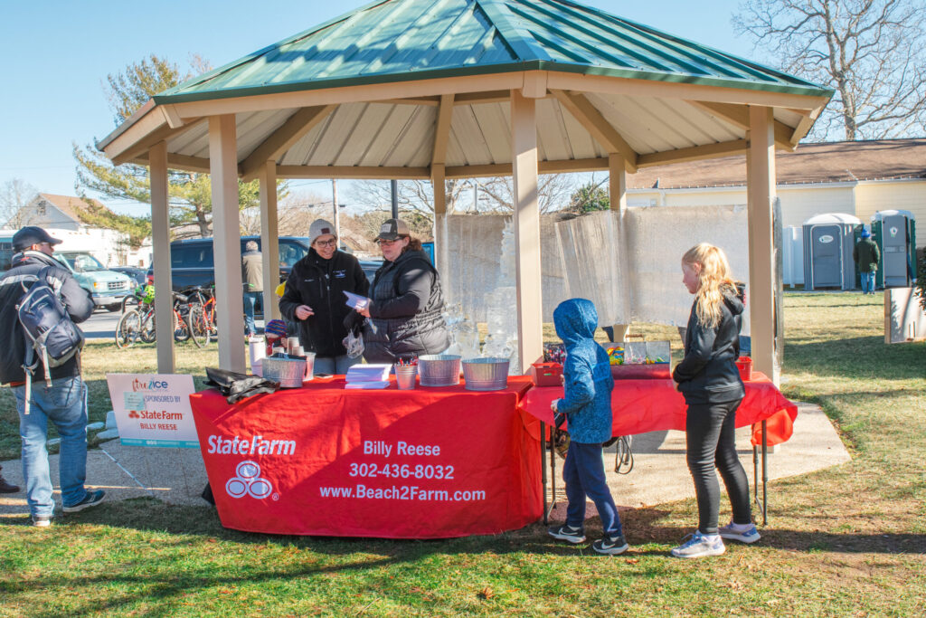 a group of people standing around a red table