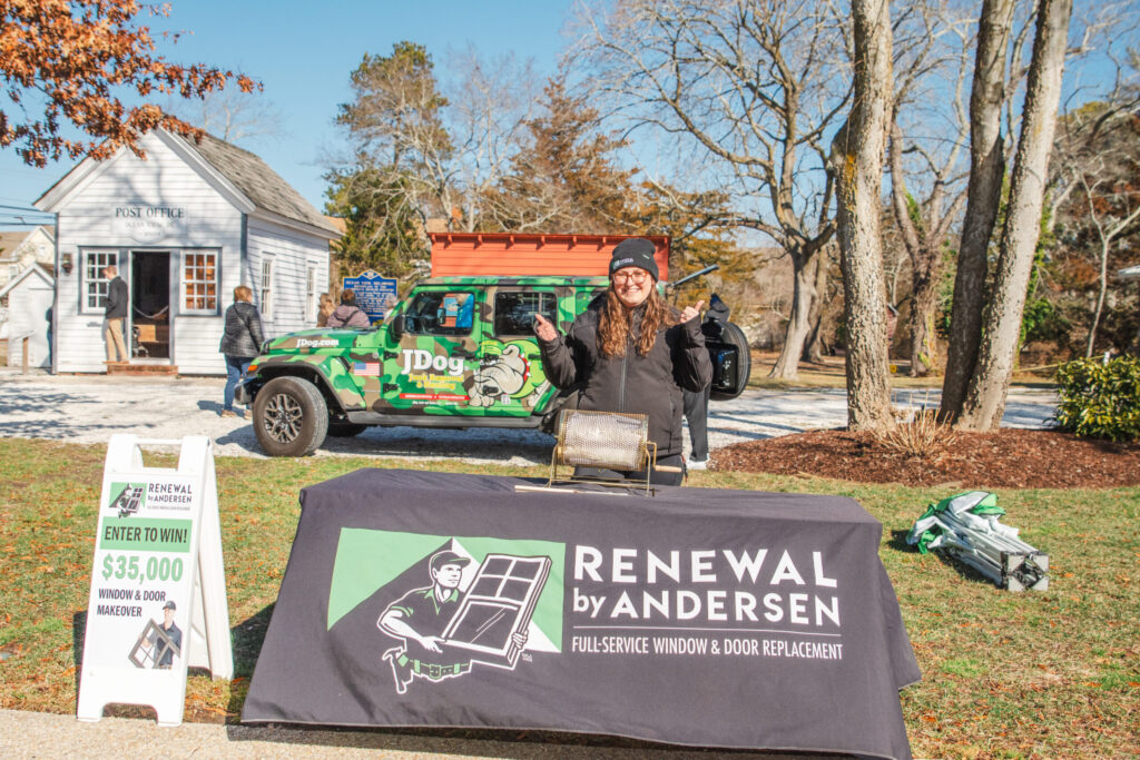 a woman standing next to a sign in front of a house