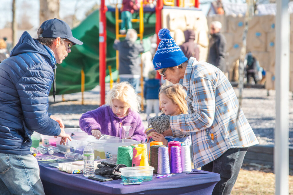 a group of people standing around a purple table