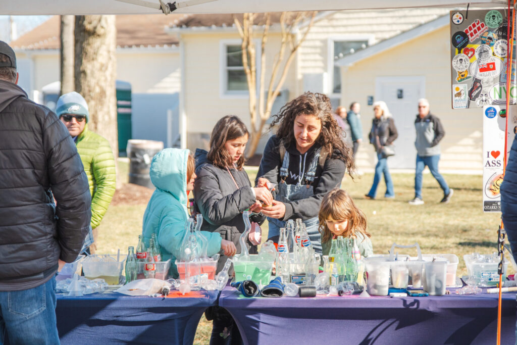 a group of people standing around a purple table