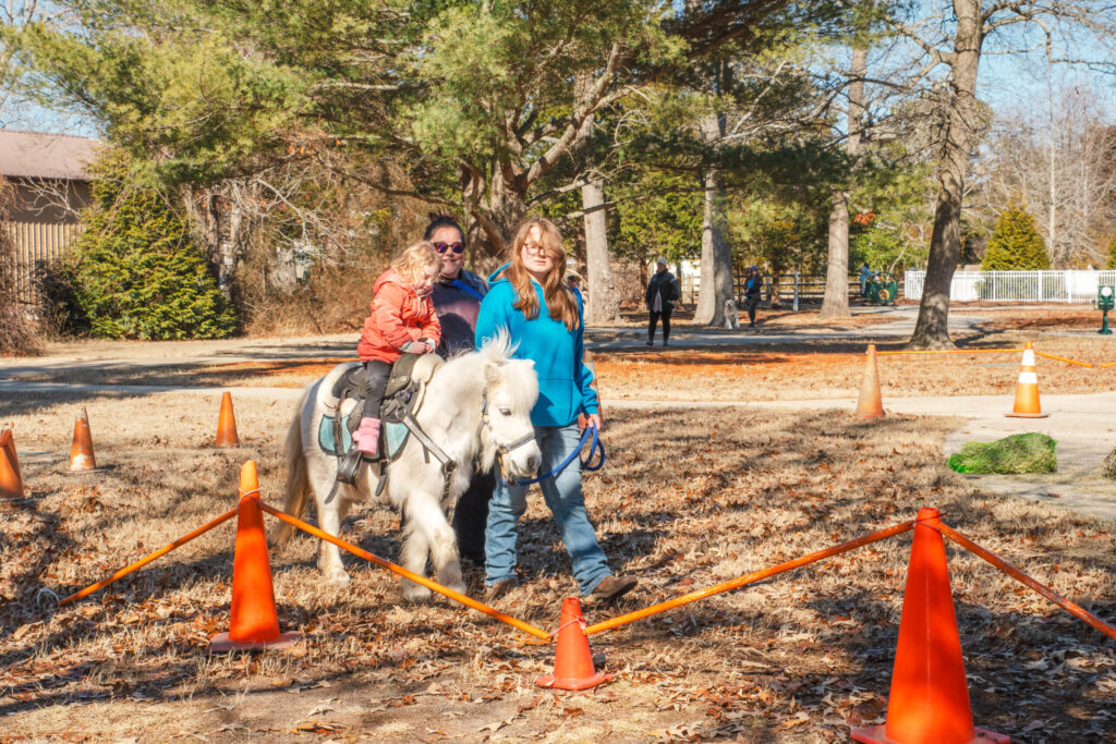 a woman and a child are riding a horse