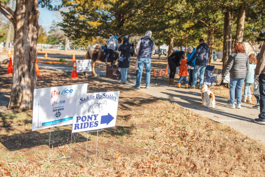 a group of people walking down a sidewalk next to trees