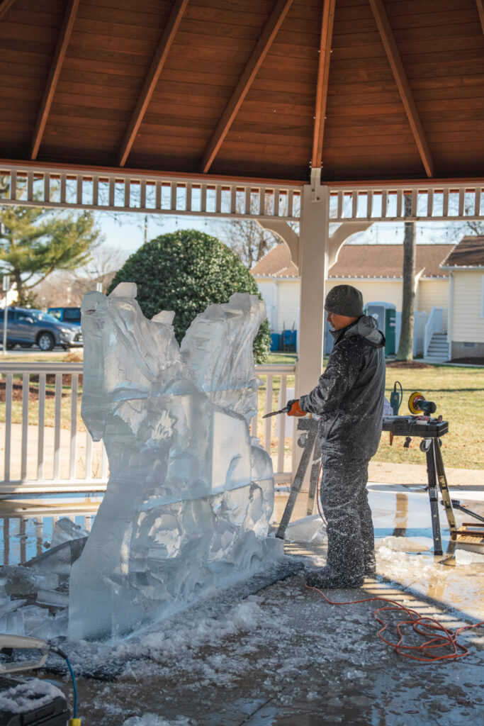 a man working on a sculpture in a covered area