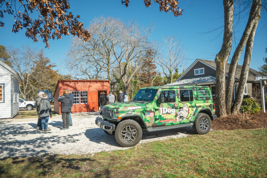a green jeep parked in front of a house