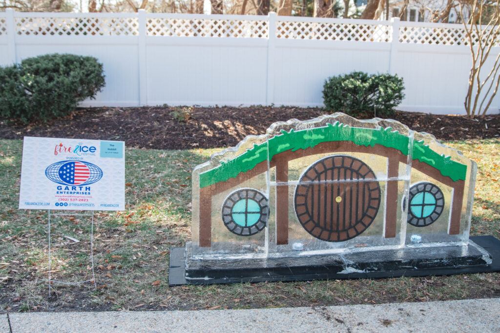 a small building made out of cardboard sitting on the side of a road