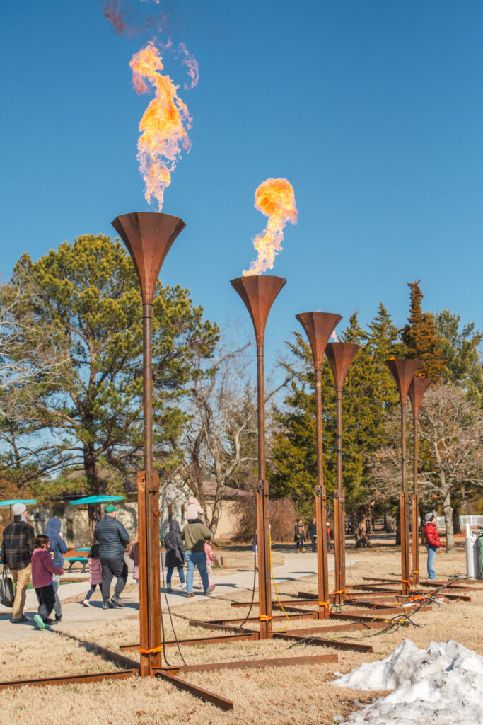 a group of people standing around a fire pit