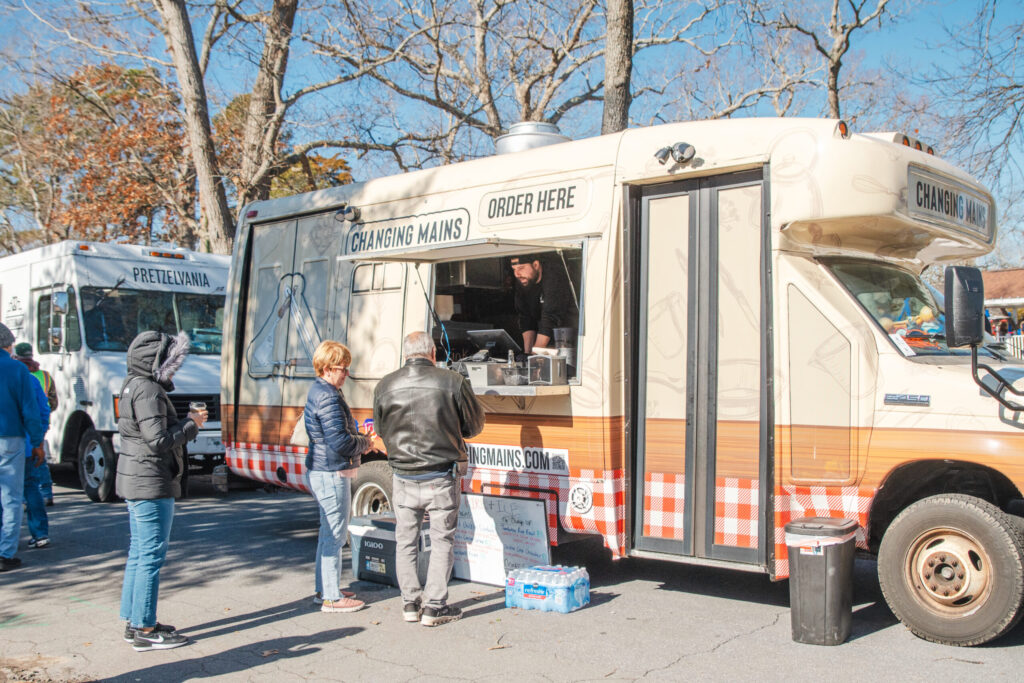 a group of people standing outside of a food truck