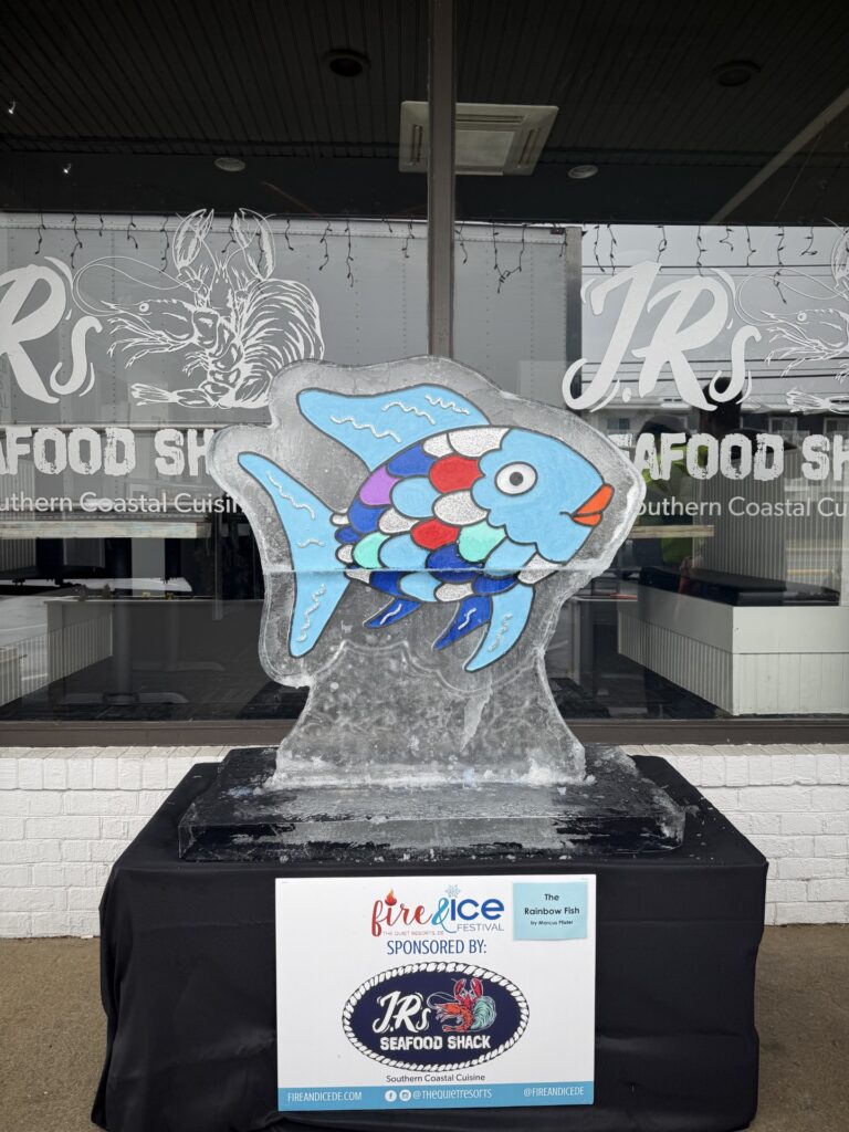a sculpture of a fish in front of a store