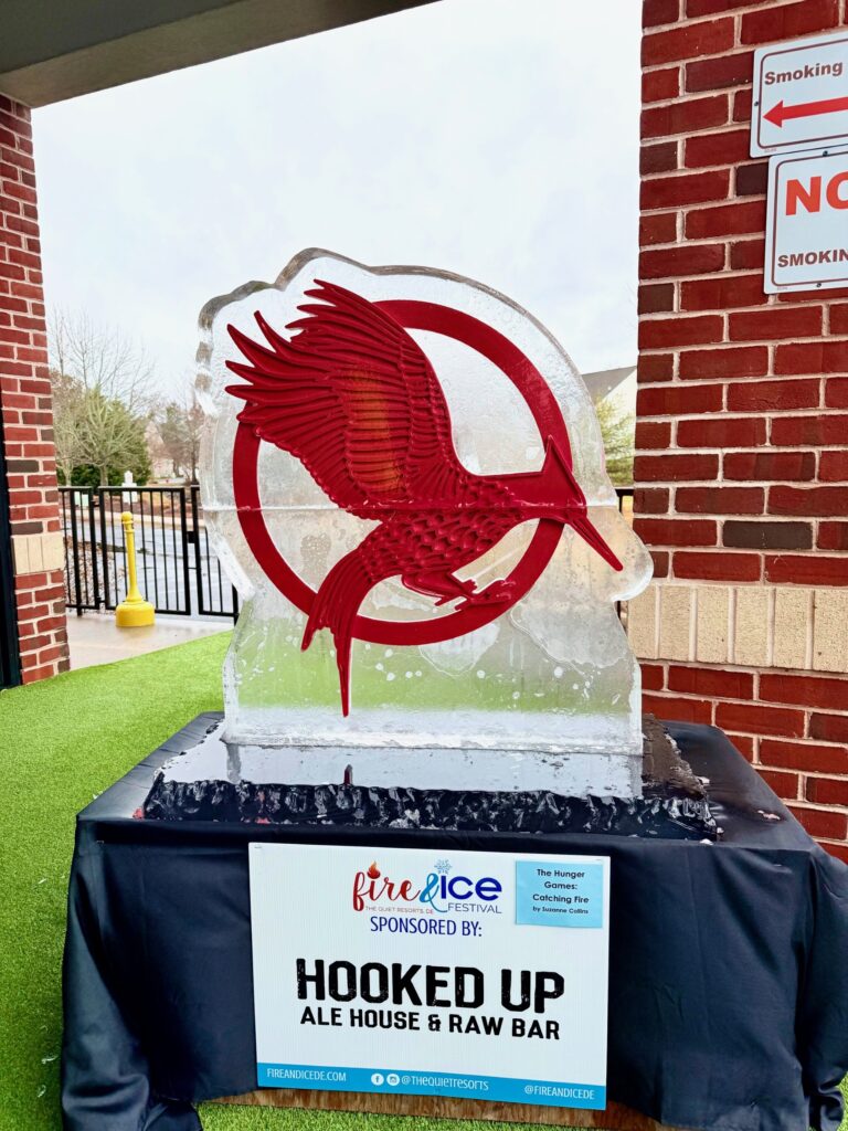 a glass trophy with a red bird on it