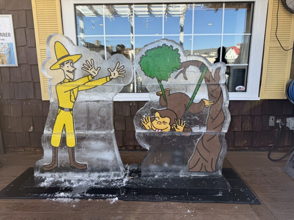 a statue of a man with a broom in front of a window