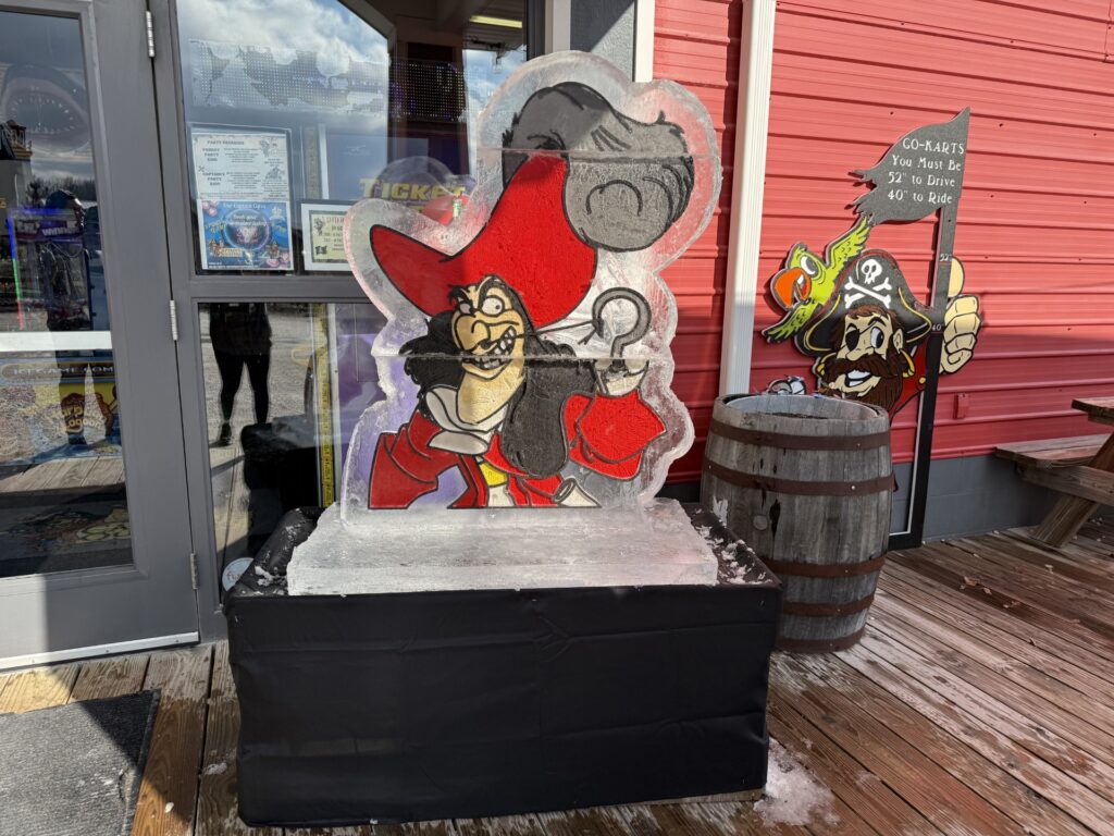 a statue of a pirate and a pirate ship in front of a building