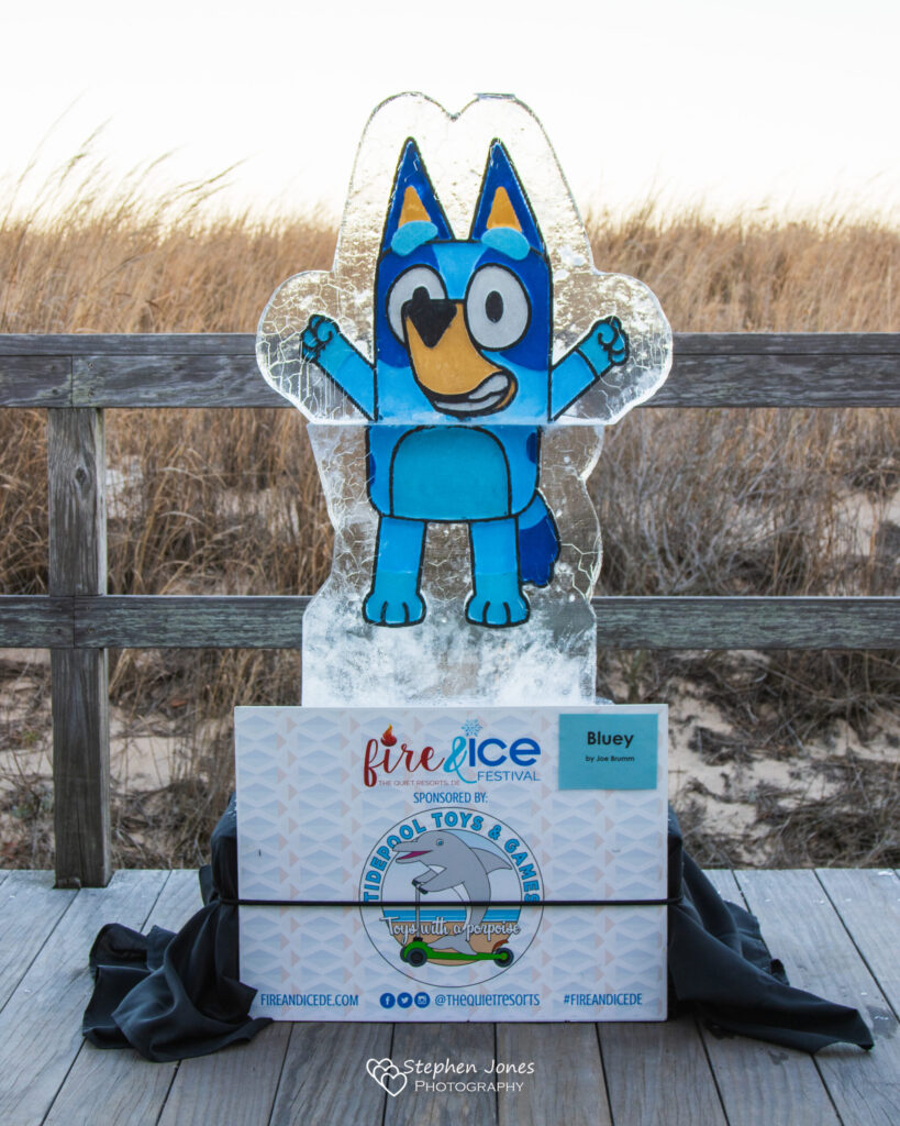 a plastic figure of a blue cat on a wooden deck