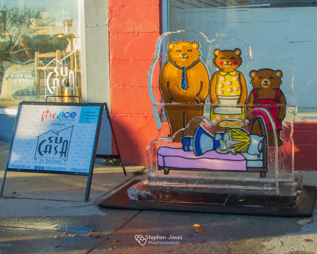 a glass sculpture of three bears on a bed