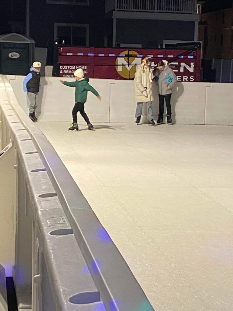 a group of people skating on an ice rink