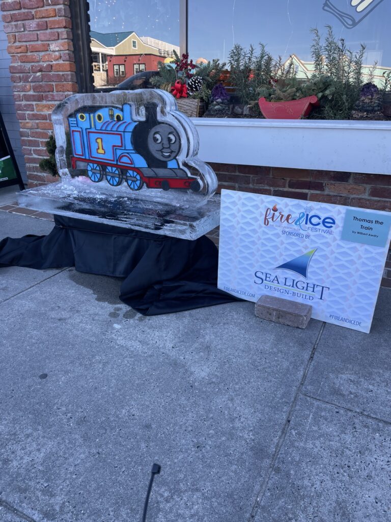 a sign sitting on the sidewalk next to a building