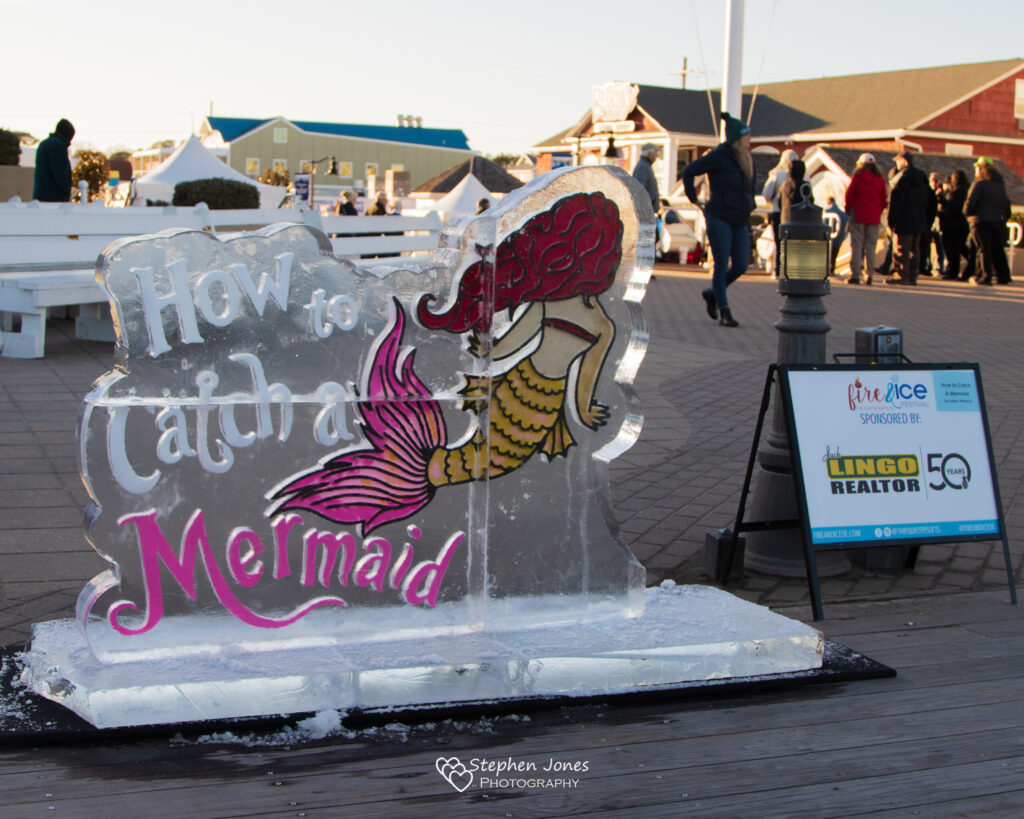 a large ice sculpture of a mermaid on the boardwalk