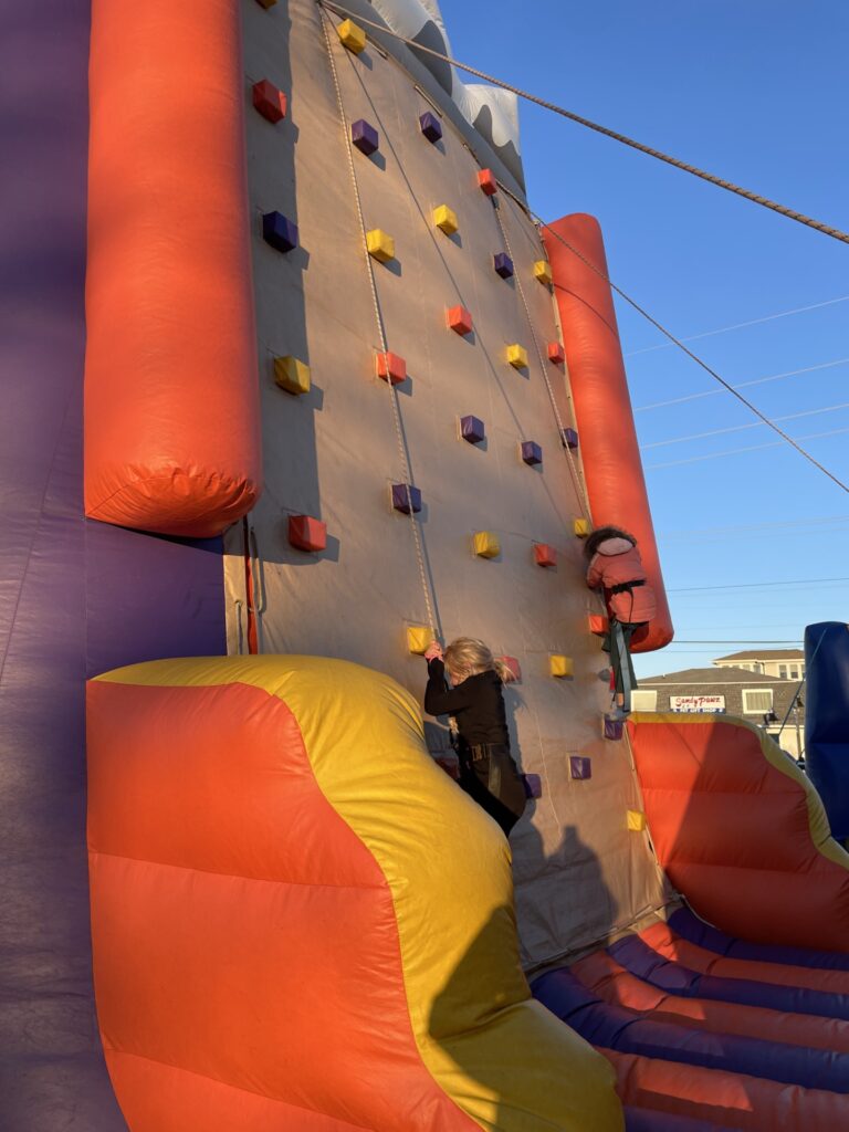 a man climbing a climbing wall in a bouncy house