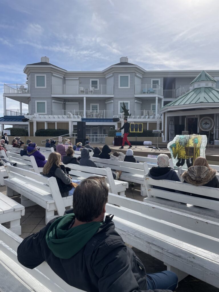 a group of people sitting on top of white benches