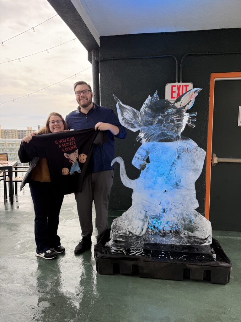 a man and a woman standing next to a statue of a cat
