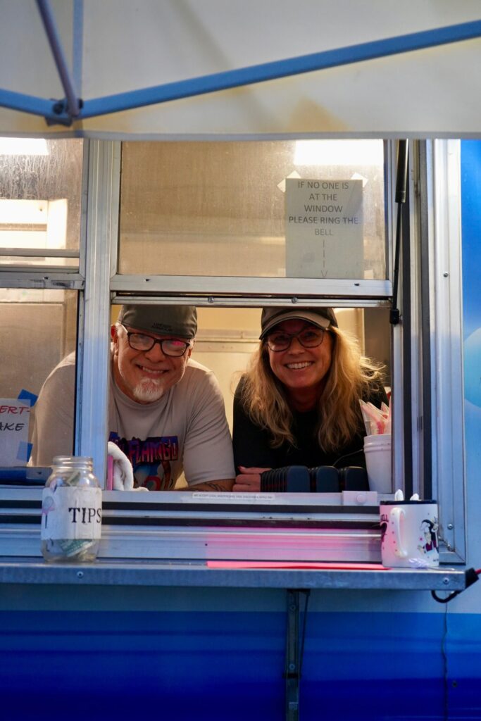 a man and a woman sitting at a food truck
