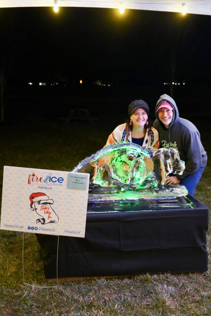 a couple of people that are standing in front of a cake
