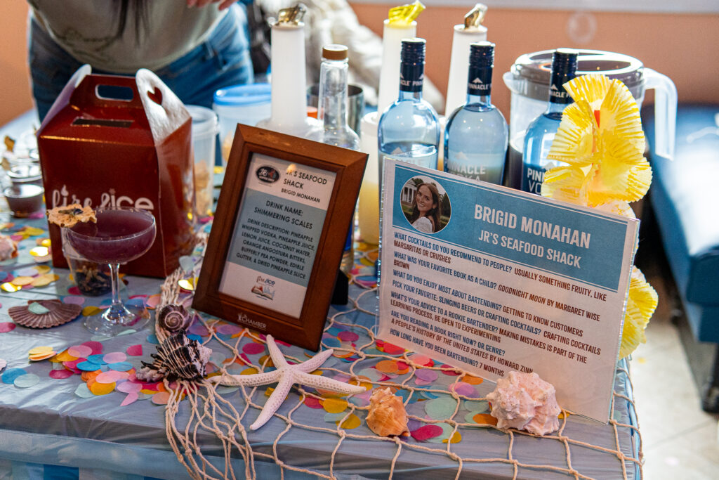 a table topped with bottles of wine and a sign