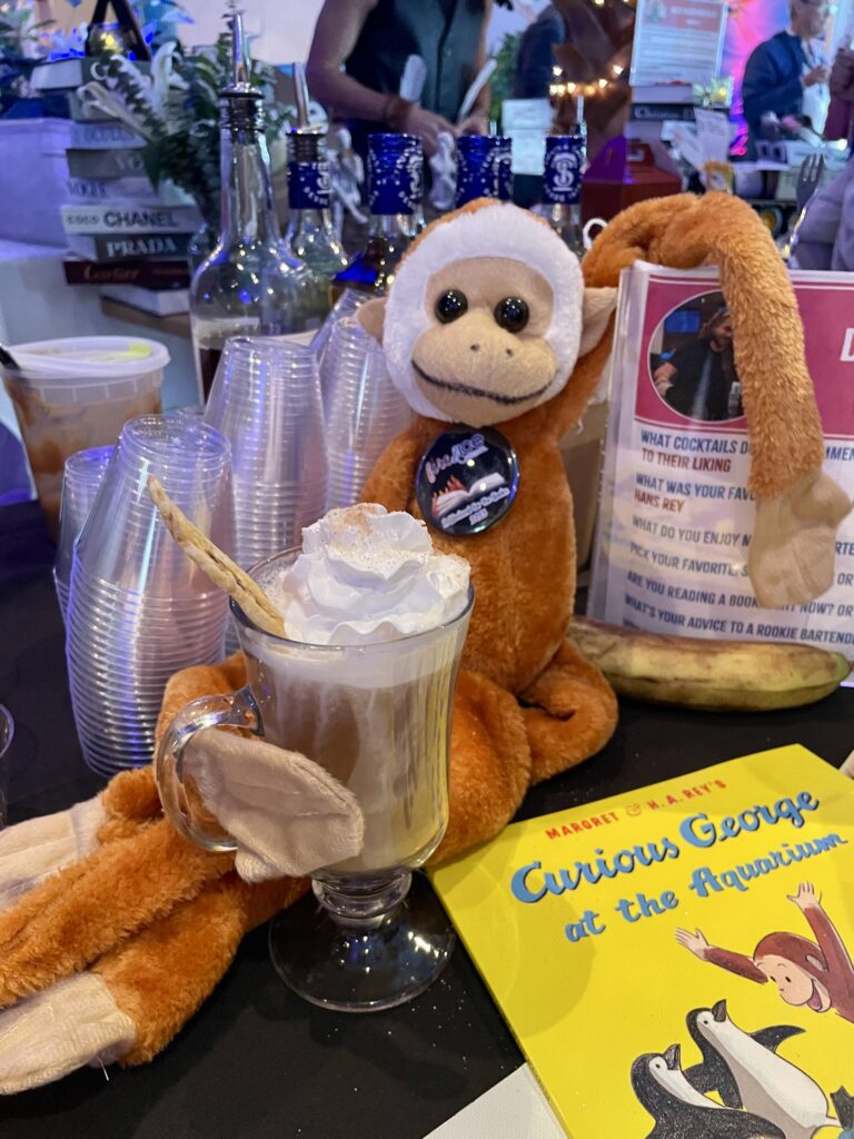 a stuffed monkey sitting next to a cup of coffee