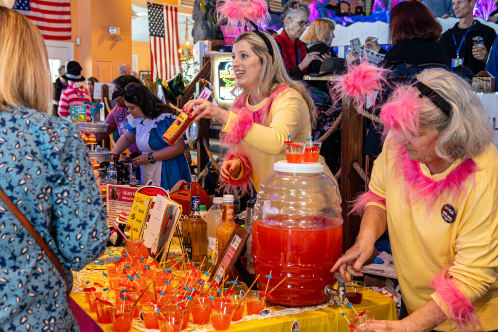 a group of women standing around a table filled with drinks