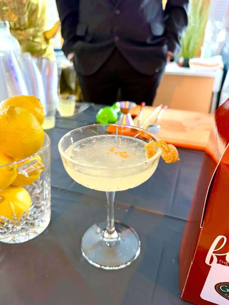 a table with a bottle of booze and a glass of lemonade