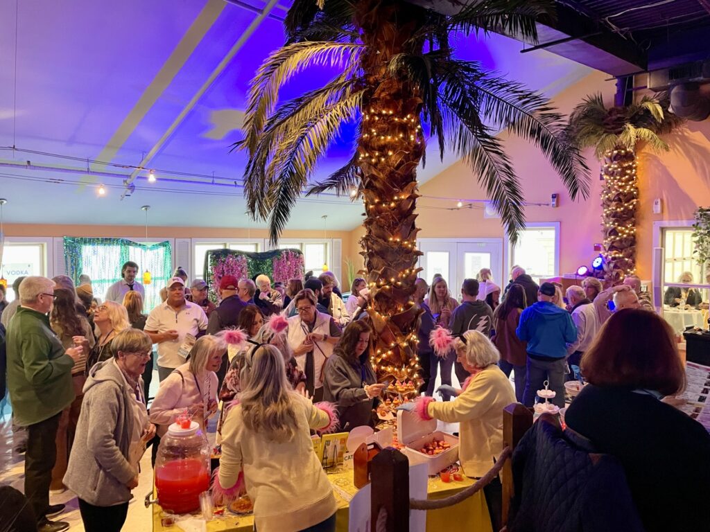 a large group of people standing around a table