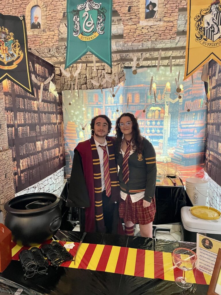 two women standing in front of a harry potter display