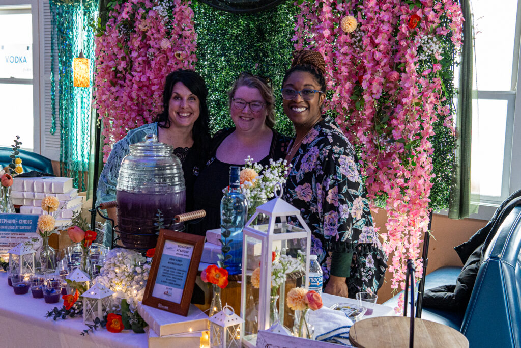 a group of women standing next to a table covered in flowers