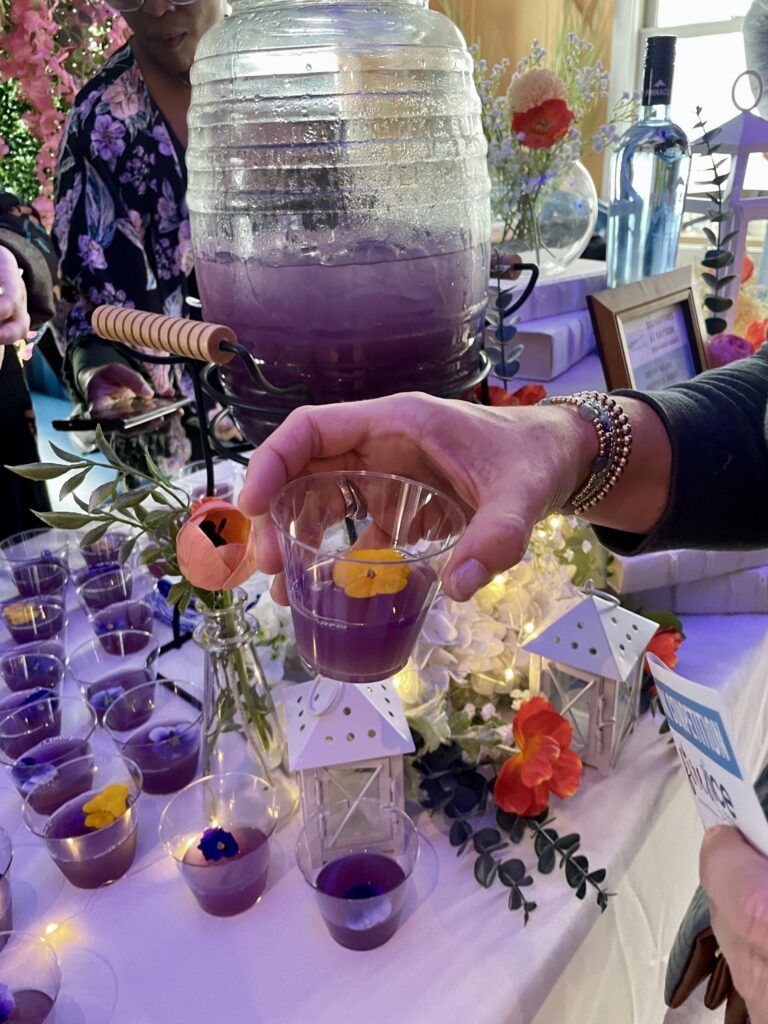a table topped with lots of purple drinks