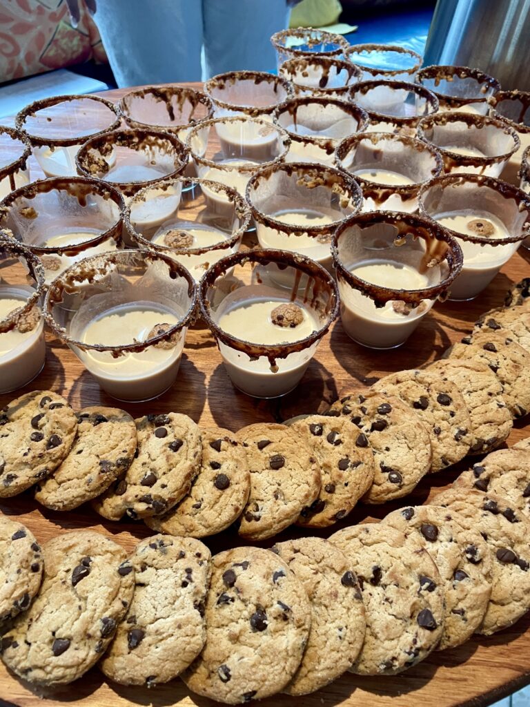 a wooden table topped with lots of cookies and cups