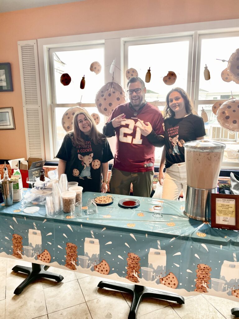 a group of people standing behind a table with food on it