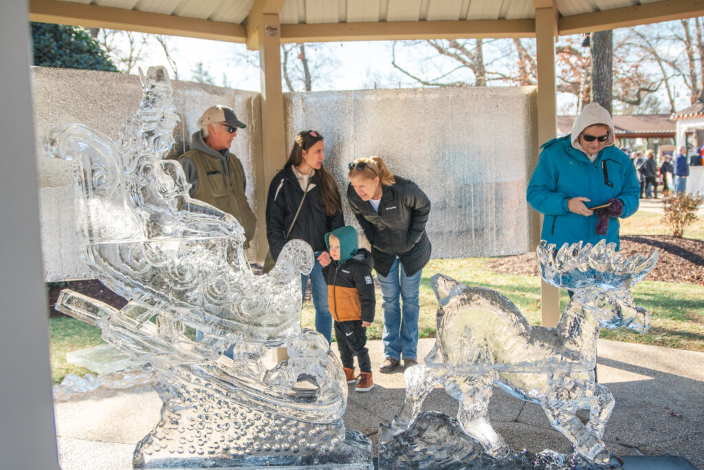 a group of people standing around a glass sculpture