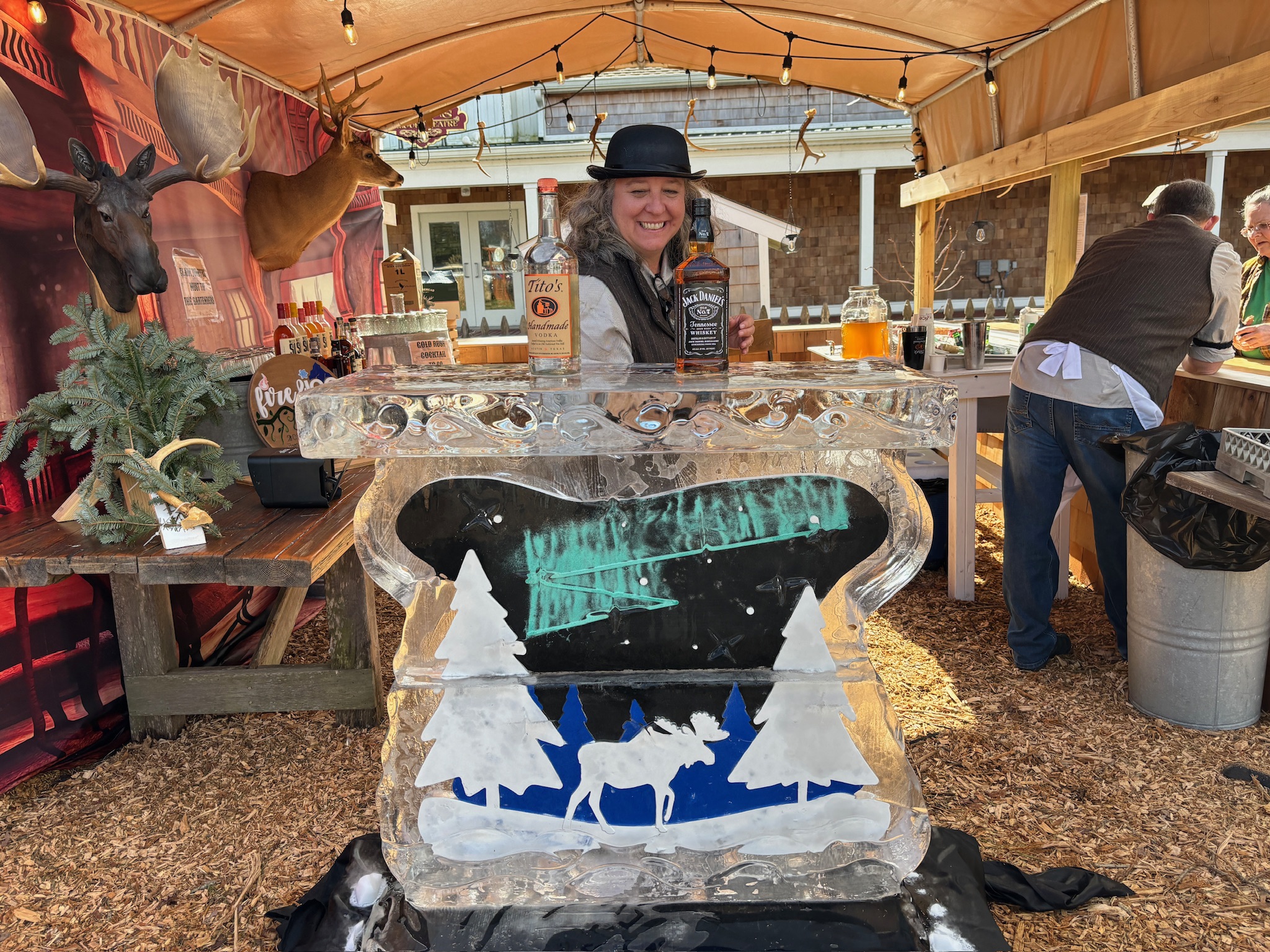 a woman in a cowboy hat standing next to an ice sculpture
