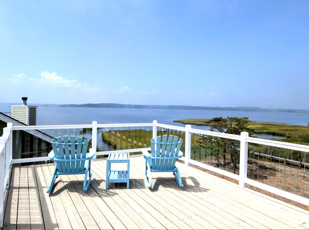 a deck with two chairs and a table on it
