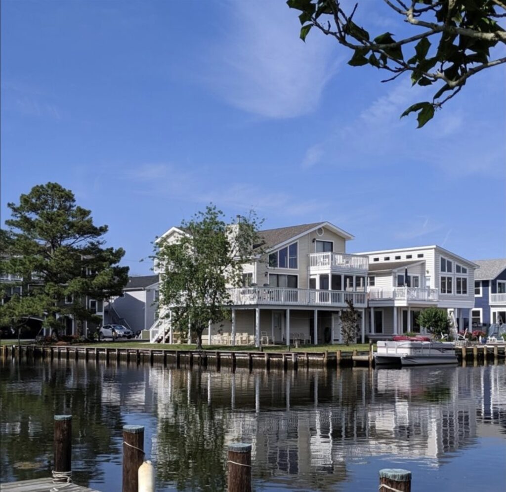 a house on the water with a boat in front of it