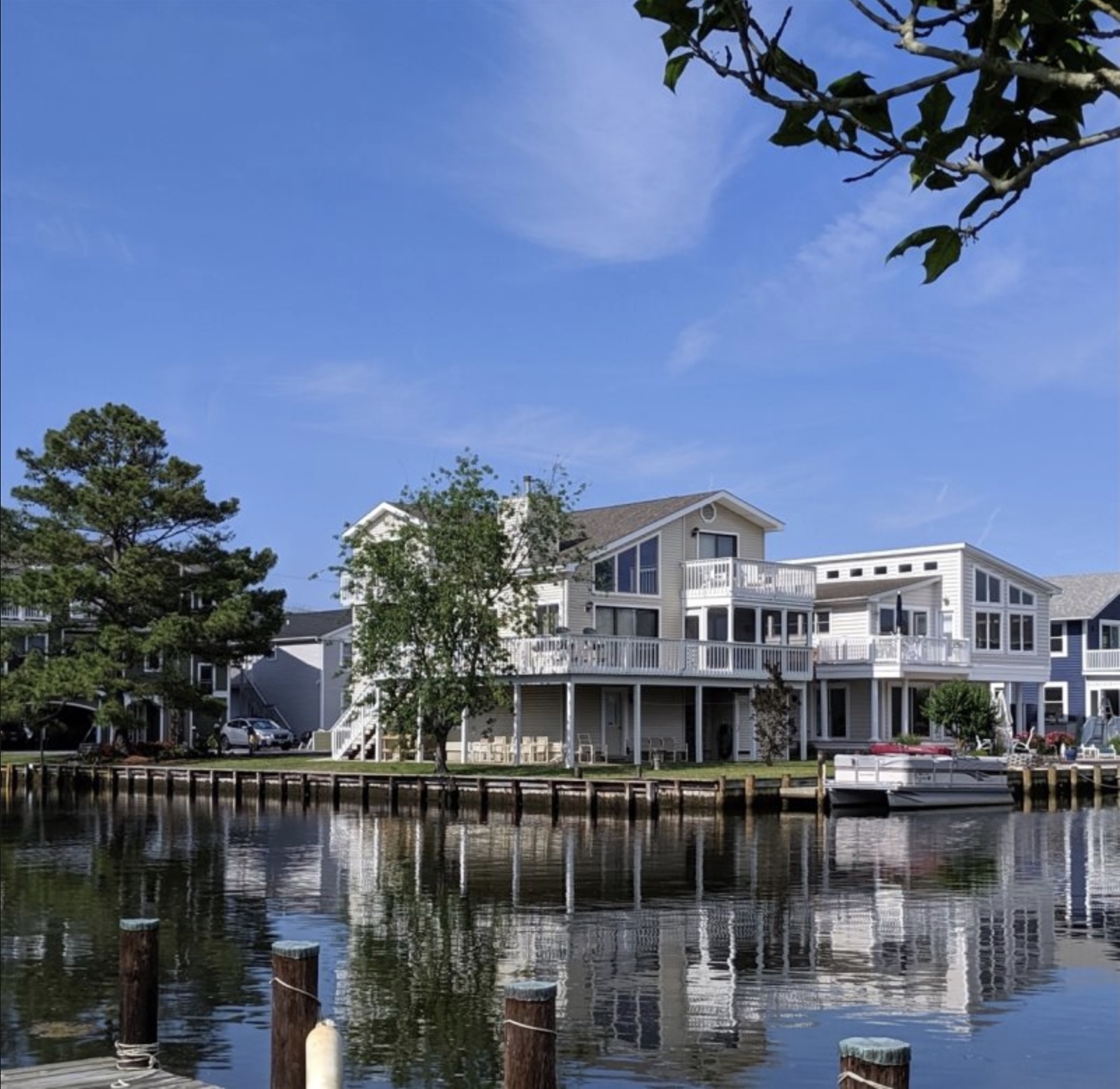 a house on the water with a boat in front of it